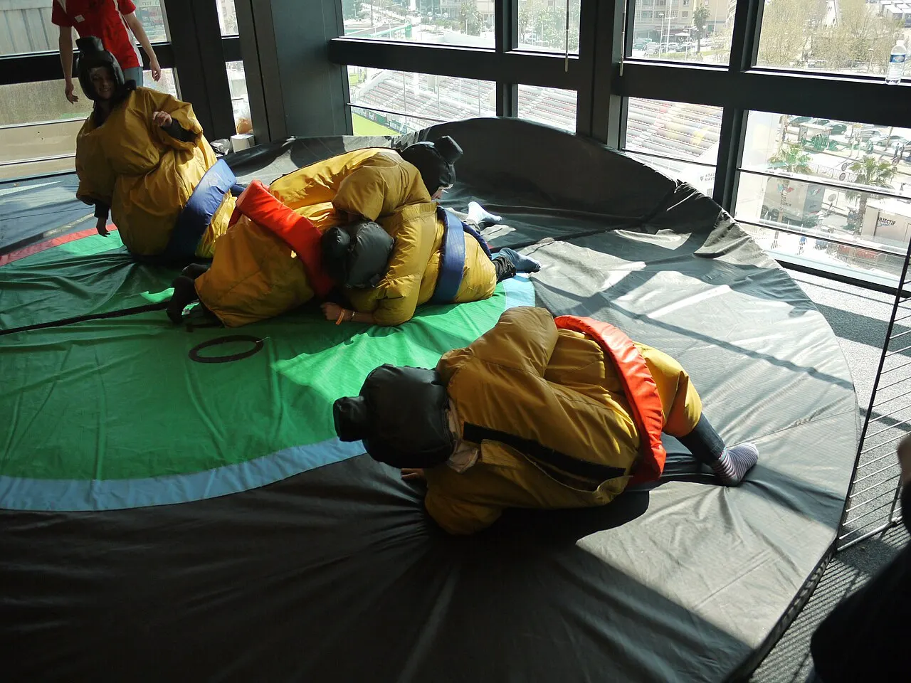 Joueurs en combinaison de sumo qui luttent sur le tapis